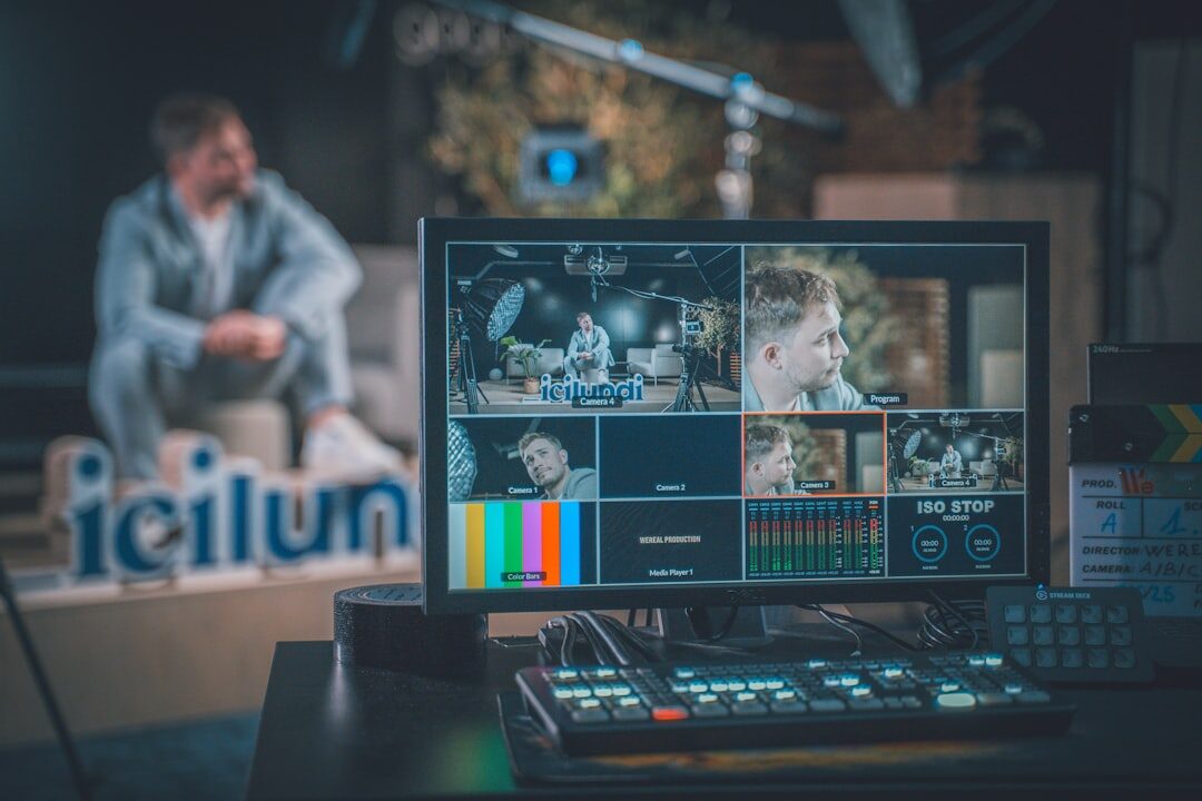 News professional working at broadcast production desk with multiple screens